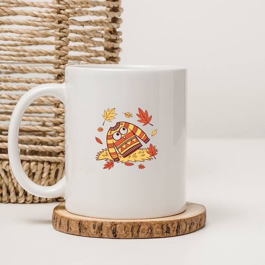 Mug automnal avec icône cosy d'un pull effrayé et feuilles flottantes