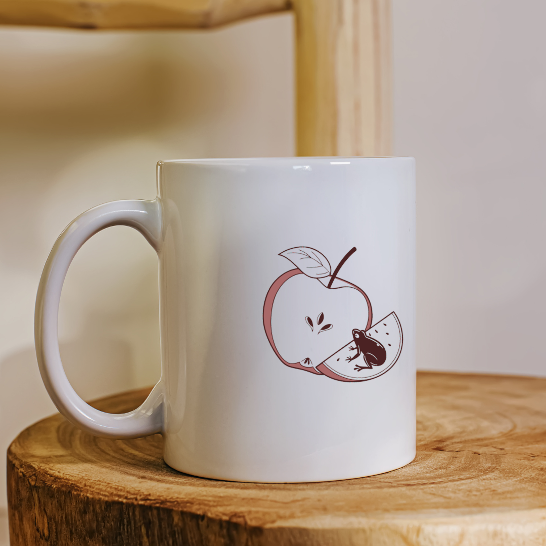 Mug orné d'une grenouille curieuse style doodle avec une pomme croquée