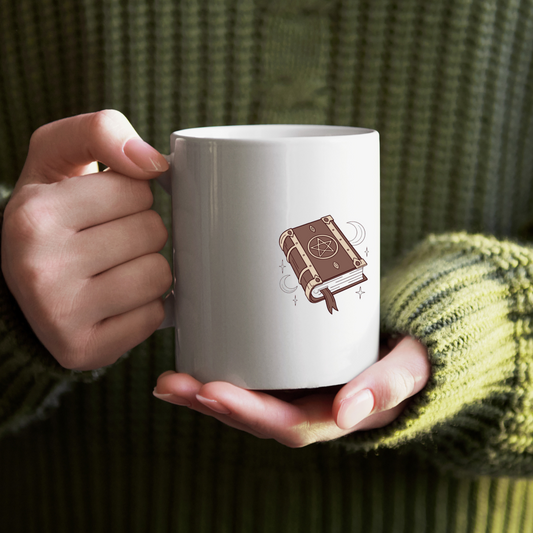 Mug avec motif mystique d’un livre enchanté flottant dans une ambiance nocturne