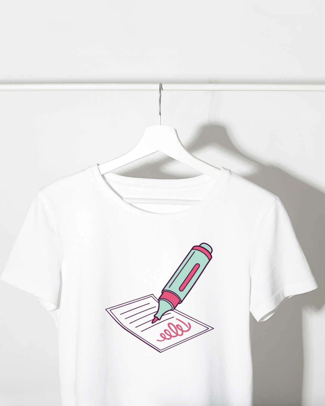 T-shirt avec design pastel et stylo fluorescent, ambiance papeterie moderne