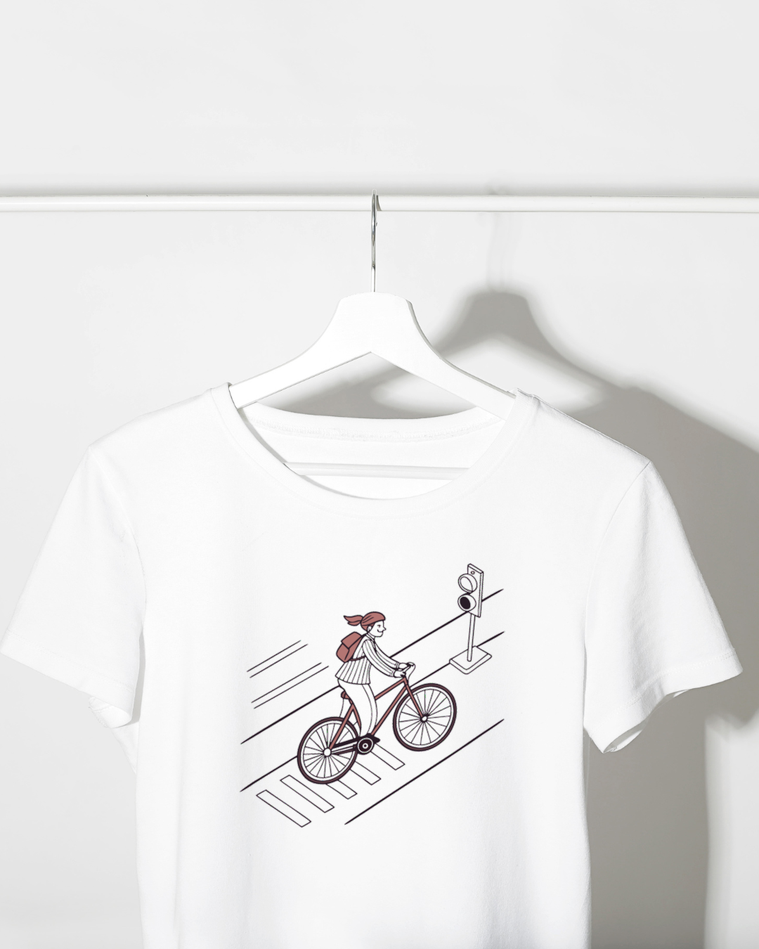 T-shirt affichant un cycliste souriant sur fond minimaliste, idéal pour les passionnés de vélo urbain