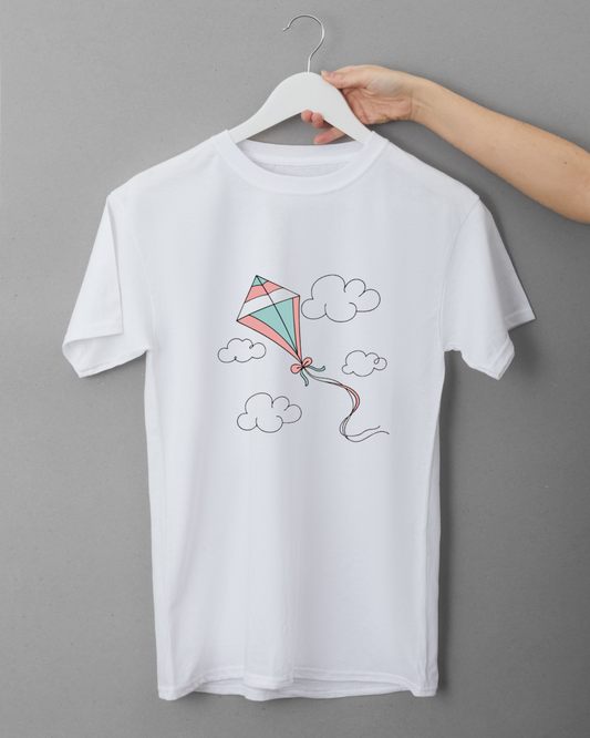 T-shirt enfantin avec cerf-volant pastel volant joyeusement dans un ciel bleu clair