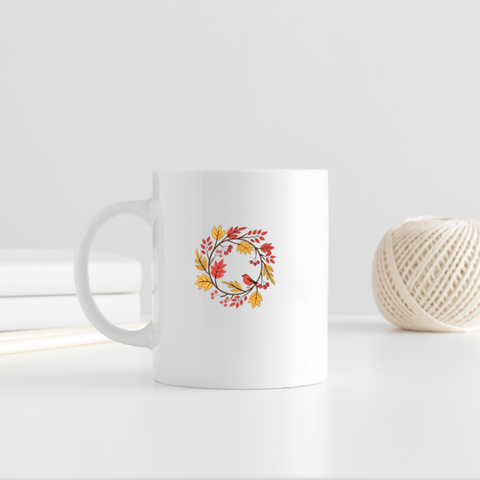 Mug décoré d'un oiseau entouré de feuillage automnal dans des tons pastel