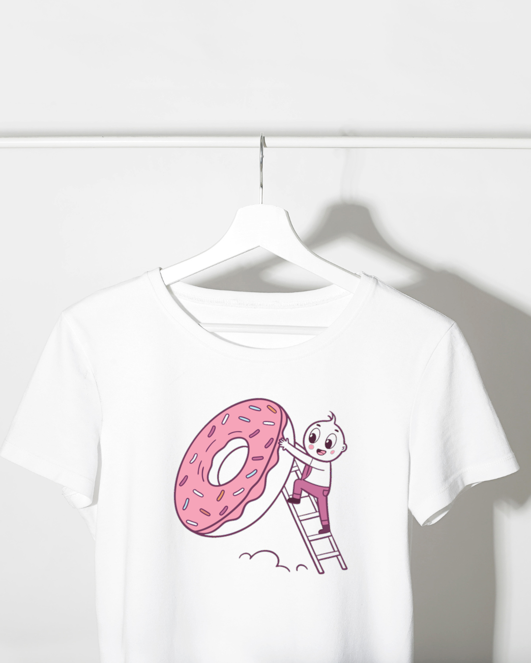 T-shirt avec enfant escaladant un donut géant dans un style créatif et coloré