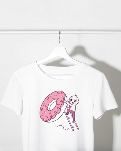 T-shirt avec enfant escaladant un donut géant dans un style créatif et coloré