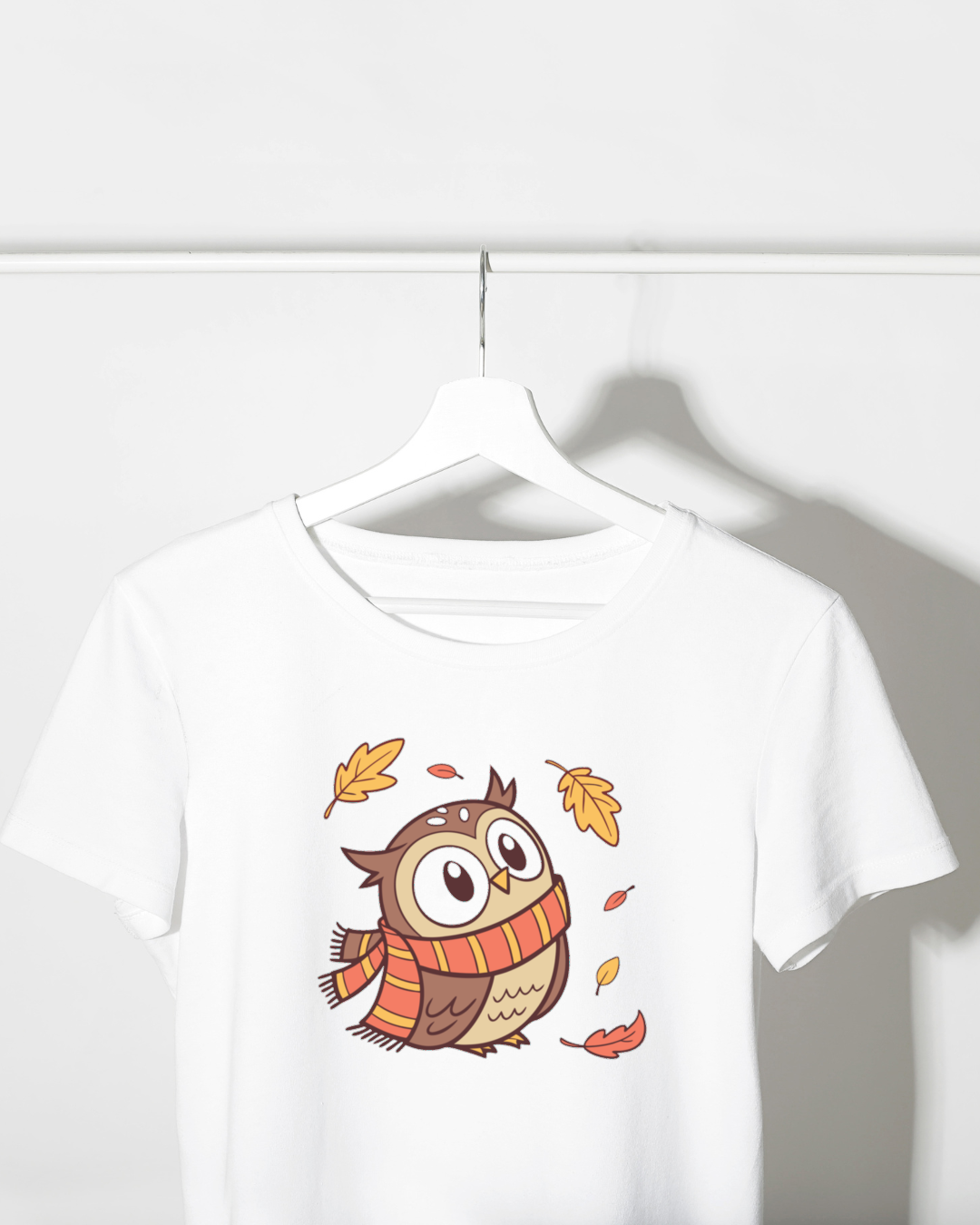 T-shirt automnal avec chouette en écharpe entourée de feuilles dansantes