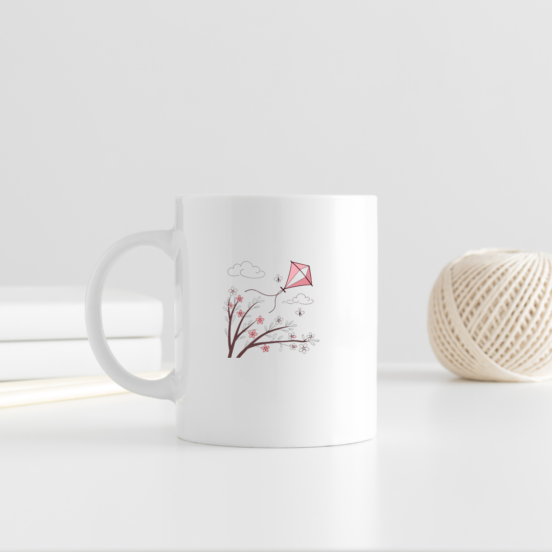 Mug décoratif avec cerf-volant pastel flottant au-dessus de fleurs printanières