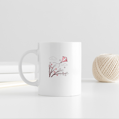 Mug décoratif avec cerf-volant pastel flottant au-dessus de fleurs printanières