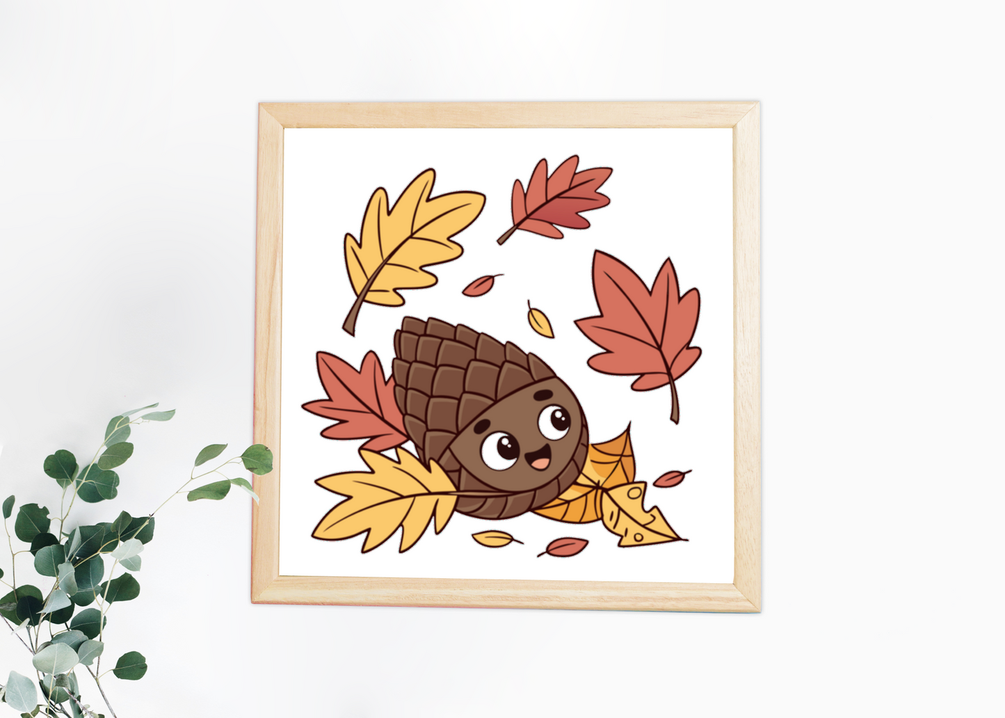 Cadre représentant une pomme de pin joyeuse au cœur de feuilles automnales