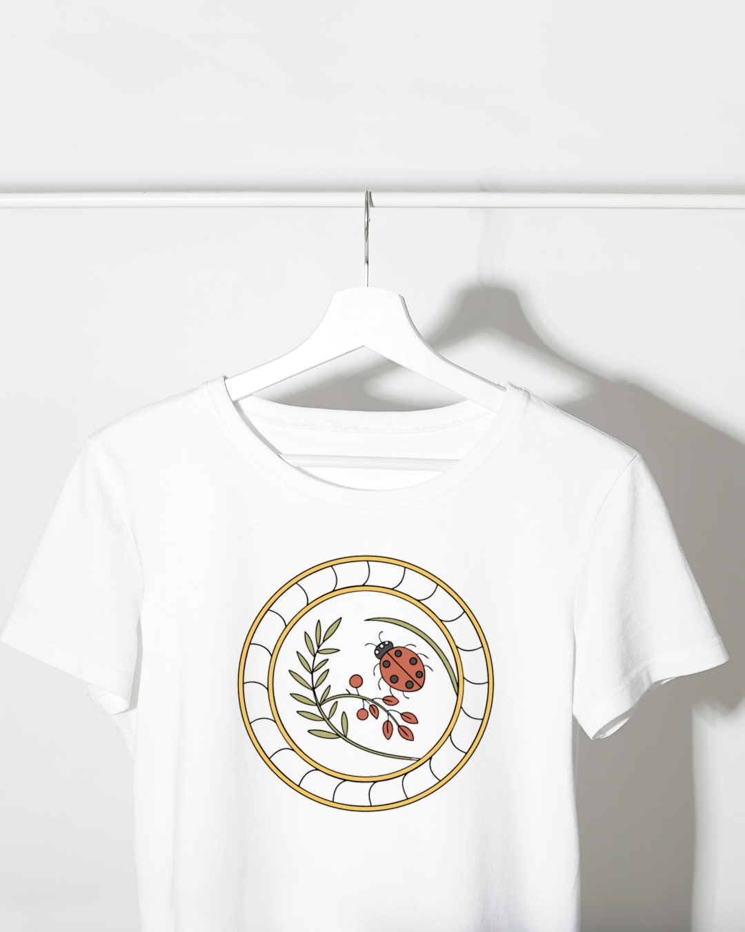 T-shirt avec motif coccinelle sur fond floral élégant et naturel