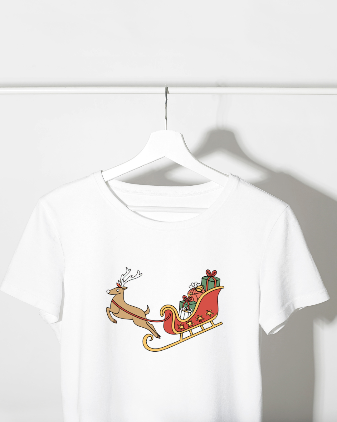 T-shirt festif avec un joyeux renne et son traîneau magique devant décor de Noël