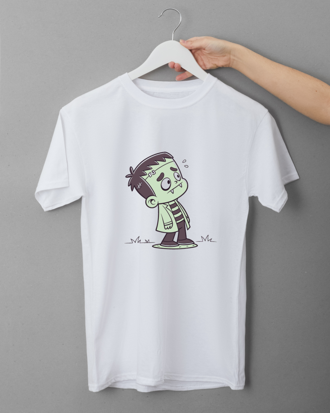 T-shirt avec motif Halloween montrant un petit monstre surpris dans un style cartoon