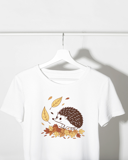 Un t-shirt affichant un hérisson curieux parmi des feuilles d'automne pastel
