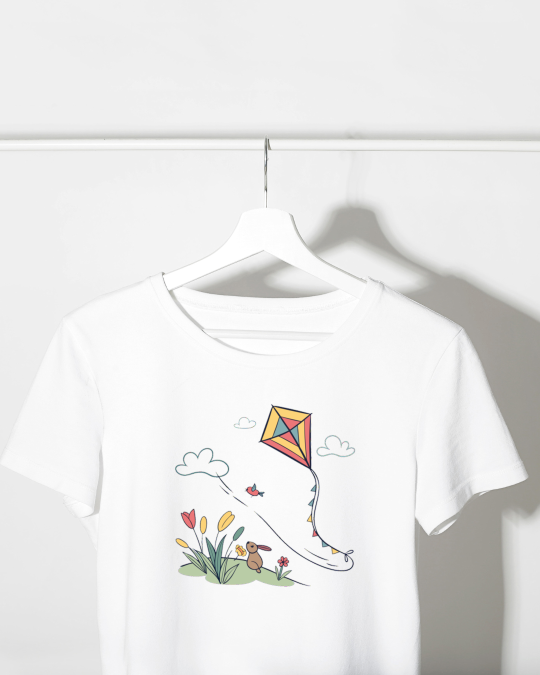T-shirt coloré décoré d'un cerf-volant joyeux qui s'envole au printemps