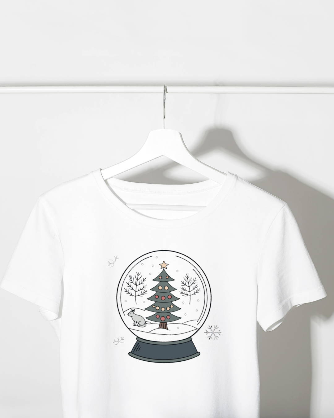 T-shirt avec un renard curieux dans une boule de neige sur un fond festif et hivernal