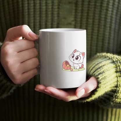 Adorable chat pastel tenu sur un mug joueur avec une balle créant un effet mignon