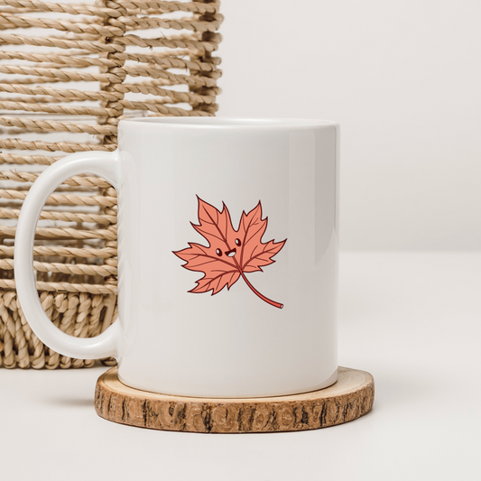 Mug décoré d'une feuille d'automne kawaii souriante évoquant un thème automnal