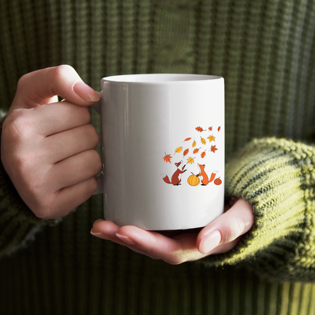 Mug avec renards espiègles cachés sous des feuilles d'automne, style ludique
