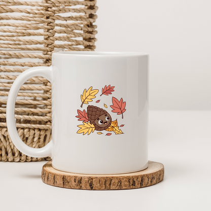 Mug coloré avec pomme de pin joyeuse entourée de feuilles d'automne