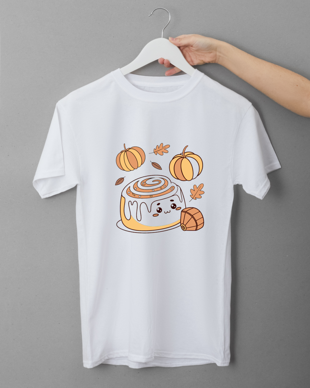 T-shirt avec design pastel automnal montrant un rouleau à la cannelle joyeux