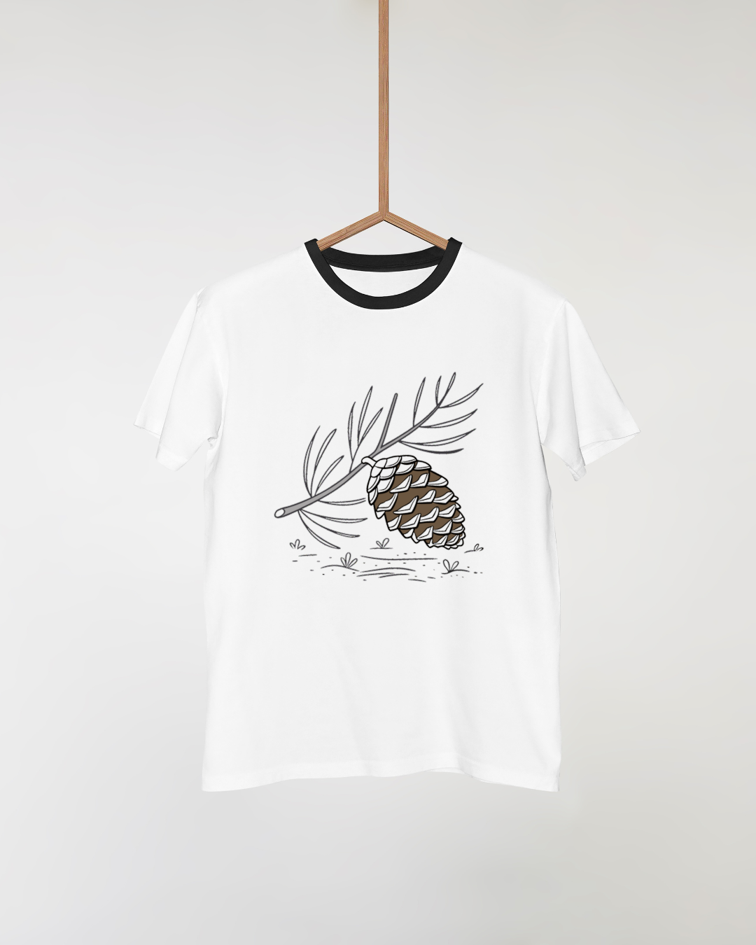 T-shirt chic orné d'une pomme de pin minimaliste en équilibre dans un style nature