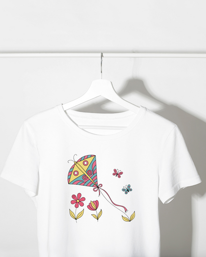T-shirt vibrant avec cerf-volant joyeux et papillons dans un jardin de fleurs pastel
