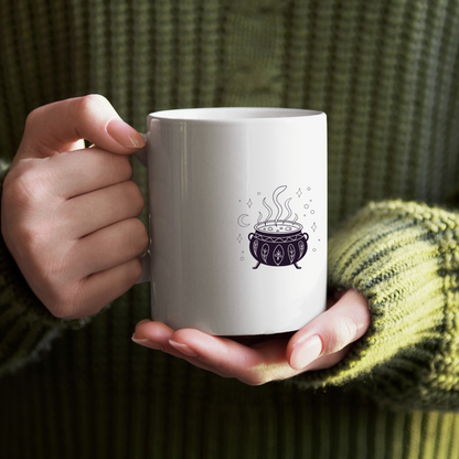 Mug arborant un chaudron aux détails mystiques noires sur fond clair